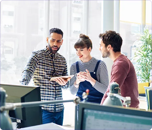 three people talking and looking at a computer monitor